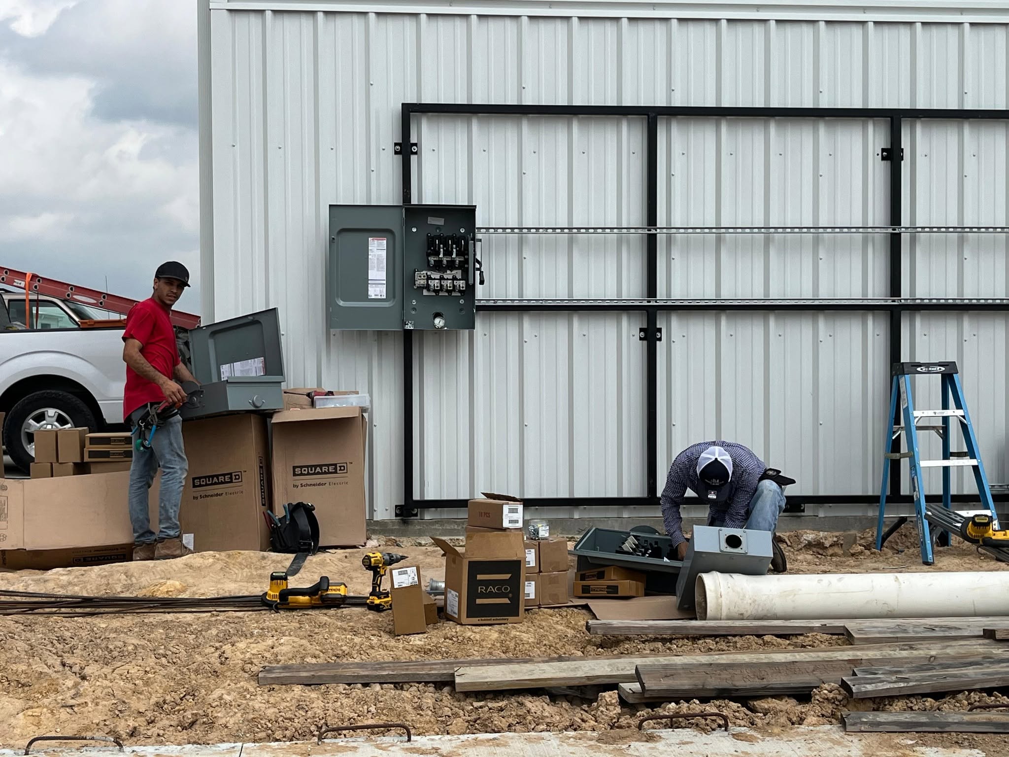 Electricians mounting switch boxes on strut frame