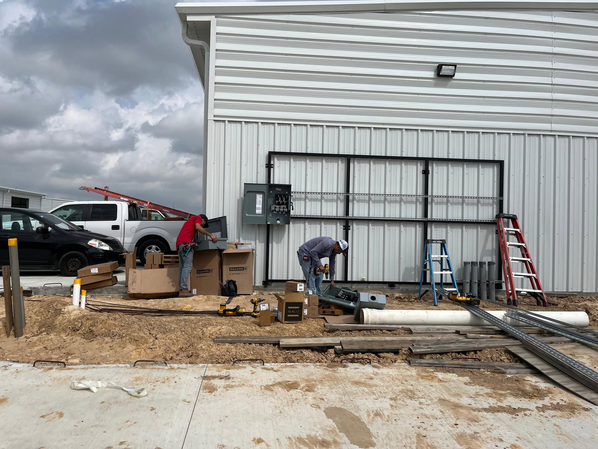 Electricians installing disconnect switches on building exterior