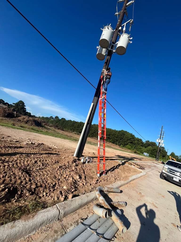 Lineman working on utility pole with transformers